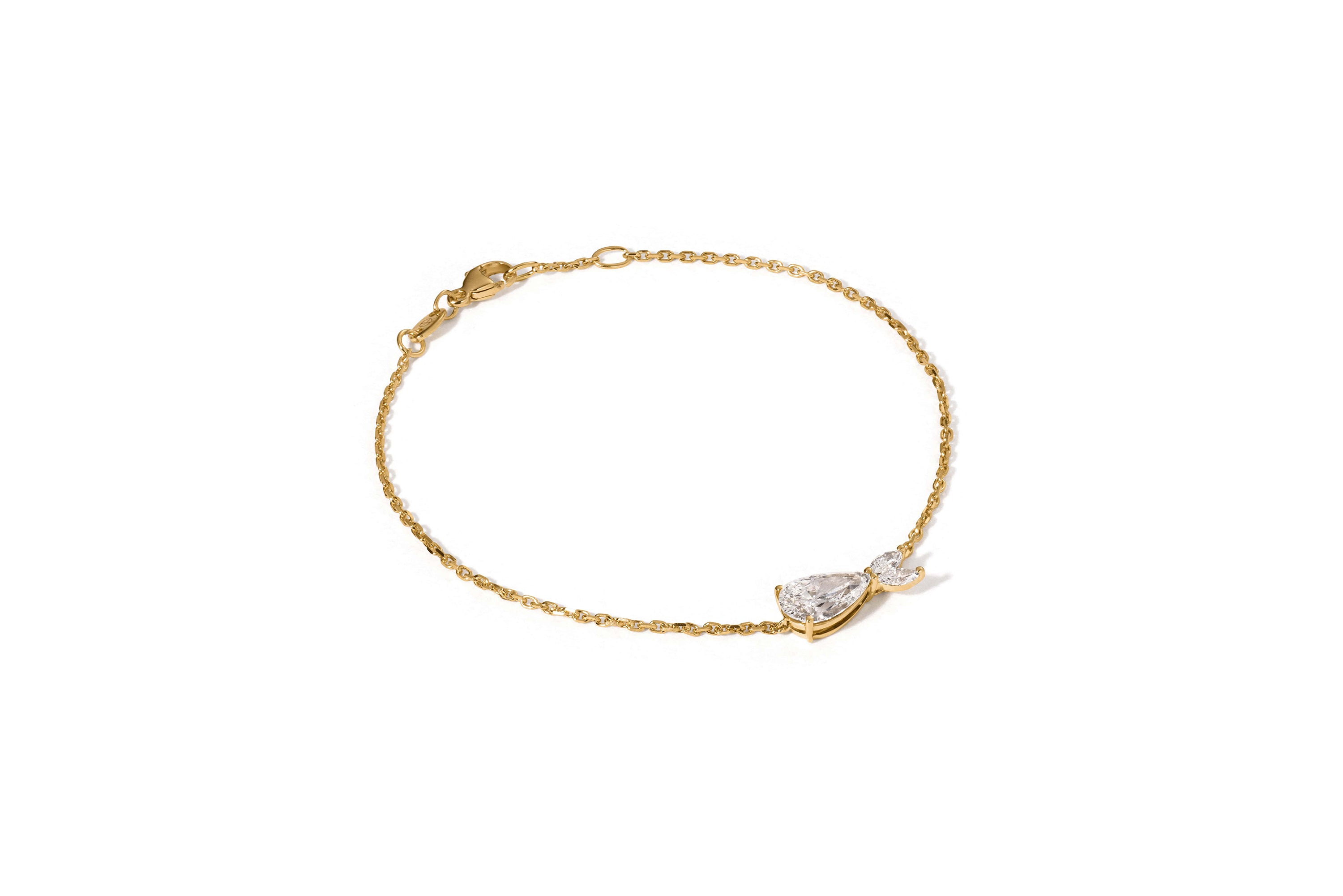 Das DIONE GELBGOLD-Armband von Atelier Sofia ist ein zartes Stück aus 18-Karat-Gold mit einer dünnen Kette und einem tropfenförmigen Kristall-Mittelstück, inspiriert von der griechischen Meeresgöttin Dione. Es besteht aus im Labor gezüchteten Diamanten und ist mit einem Karabinerverschluss vor einem schlichten weißen Hintergrund befestigt.