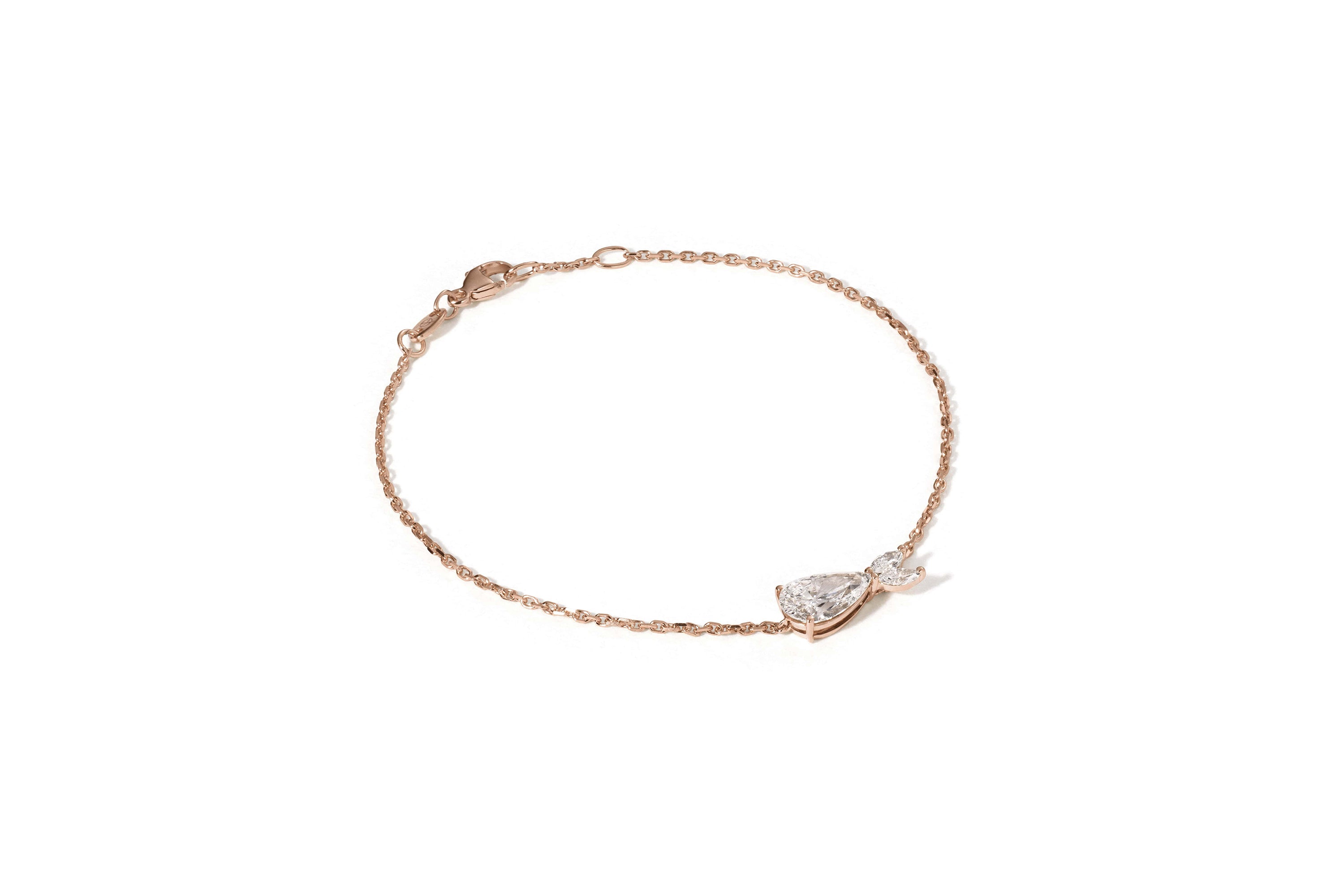 Das DIONE ROSÉGOLD von Atelier Sofia ist ein zartes Armband aus 18 Karat Roségold mit einem schillernden, im Labor gezüchteten, birnenförmigen Kristall an einem Ende, der sich elegant vor einem schlichten weißen Hintergrund abhebt.