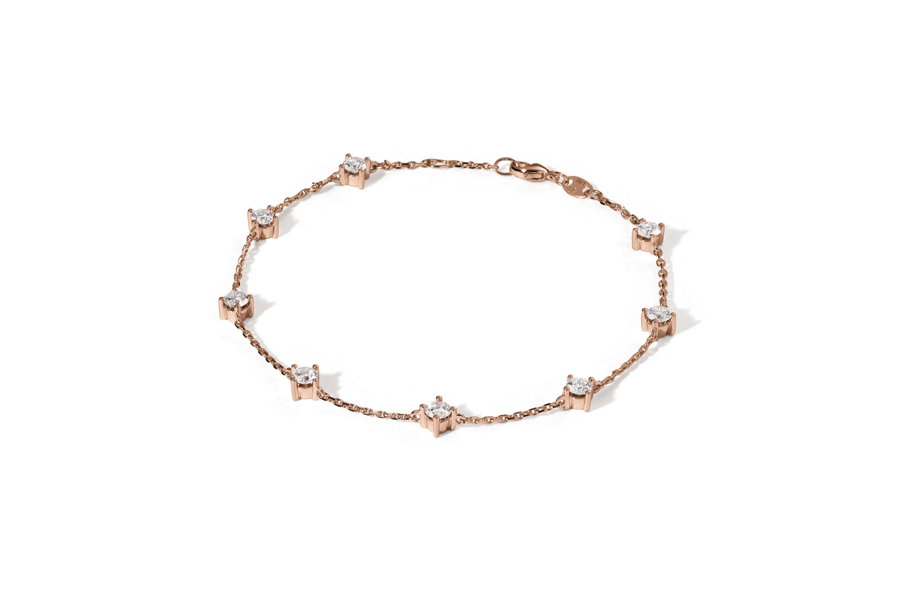 Das HESTIA ROSÉGOLD-Armband von Atelier Sofia ist ein zartes Stück aus 18 Karat Roségold mit sternförmigen Anhängern, in deren Mitte sich jeweils ein funkelnder, im Labor gezüchteter Brillant befindet, der flach auf einem weißen Hintergrund liegt.